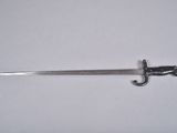 a close up of a sword on a white surface