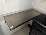 a black counter top in a kitchen with a black oven