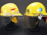 pair of yellow hard hats sitting on top of each other on a black surface