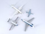 four model airplanes that are sitting on a white surface
