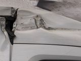 a close up of a white car with a broken hood