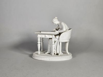 une statue représentant une femme assise à une table en train d'écrire