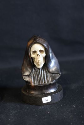 two figurines of a person with a skull on them