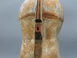 une image représentant un casque en bois posé sur un socle