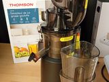 a juicer that is sitting on a table next to a cup