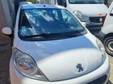 une petite voiture blanche garée sur un parking à côté d'autres voitures