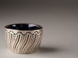 a black and white cup sitting on a table
