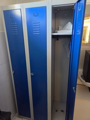 deux casiers bleus dans une salle de bains, à côté des toilettes