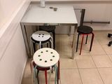 a view of a small room with a table and stools