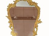 un miroir avec un cadre doré accroché au mur