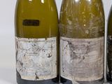 three bottles of wine sitting next to each other on a white surface