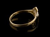 a close up of a gold ring with a diamond on a black surface