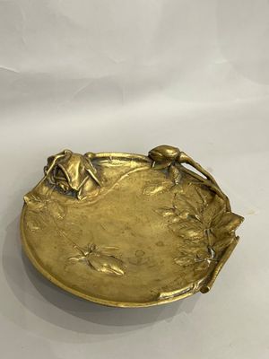 brass plate with flowers and leaves on it on a white background