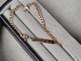 un bracelet noir et doré orné d'une chaîne dorée