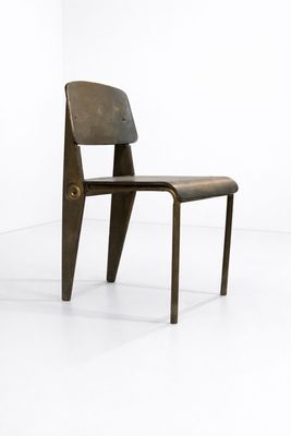 une image représentant une chaise avec une assise en bois dans une pièce blanche