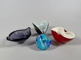 three different colored glass bowls sitting next to each other on a table