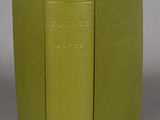 two green books sitting on top of each other on a gray surface