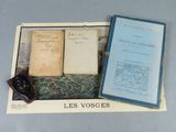 Deux livres sont posés sur une table, à côté d'une paire de lunettes.