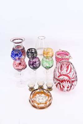 many different colored glass vases sitting on a white surface