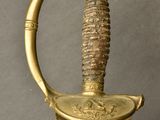 an old sword with a gold handle on a gray background