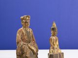 pair of carved wooden statues of a seated buddha and a seated buddha