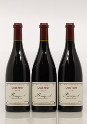 trois bouteilles de vin rouge sont alignées sur une surface blanche