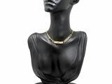 black mannequin head with gold chain necklace on display