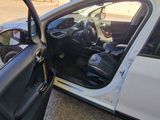 a small white car with its door open on the side of the road