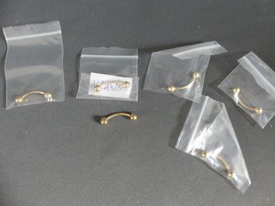 cinq pochettes de bijoux posées sur une table, accompagnées d'une étiquette nominative