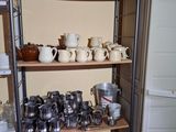 many cups and pans on the shelves in the kitchen