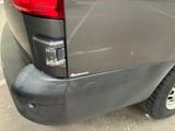 the rear end of a gray van parked in a parking lot