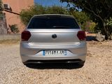 the back end of a silver car parked on a gravel road