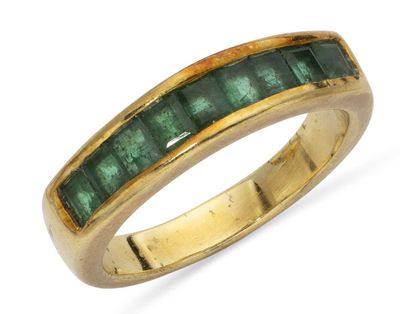 a close up of a gold ring with emerald stones