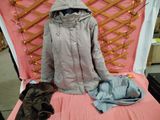 un lit recouvert d'une couverture rose et d'un manteau posé dessus