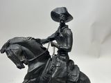 statue of a man riding a horse with a hat on his head