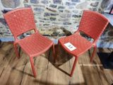 deux chaises rouges placées l'une à côté de l'autre sur un parquet