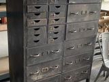 une armoire noire avec de nombreux tiroirs, dans un magasin
