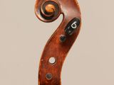 an antique violin with a scroll on the back of it