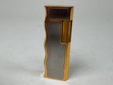 un briquet doré posé sur une table blanche