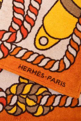 serviette orange et blanche sur laquelle est représenté un bateau et une corde