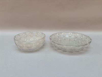 une paire de bols en verre transparent posés sur une table blanche