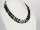 a close up of a black beaded necklace on a mannequin