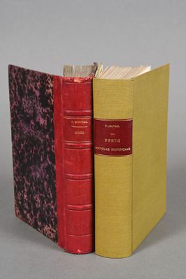 two red and yellow books sitting next to each other on a gray surface