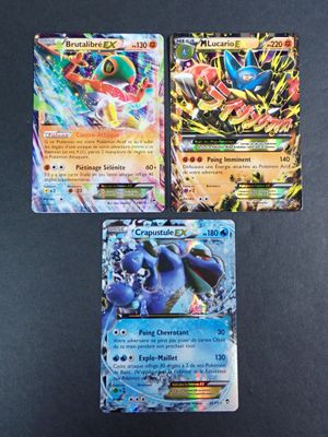 trois cartes pokemon posées les unes sur les autres sur une table