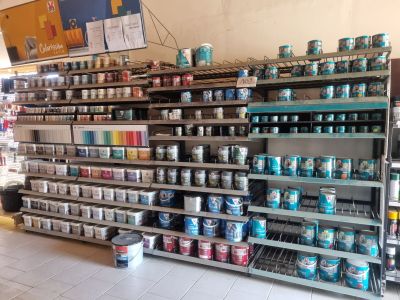 many cans of paint on the shelves in the store