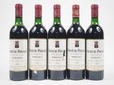 quatre bouteilles de vin sont alignées sur une surface blanche