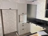 a kitchen with white cabinets and a black counter top