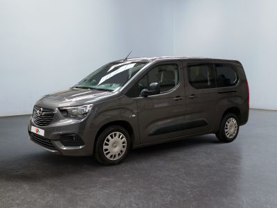 La camionnette grise est garée dans une pièce blanche au sol noir.