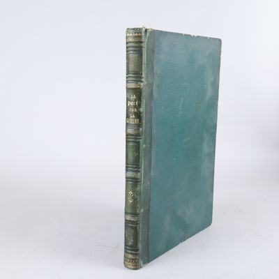 un vieux livre à la couverture verte posé sur une surface blanche