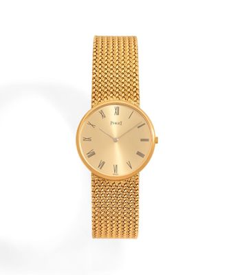 gros plan d'une montre en or sur fond blanc